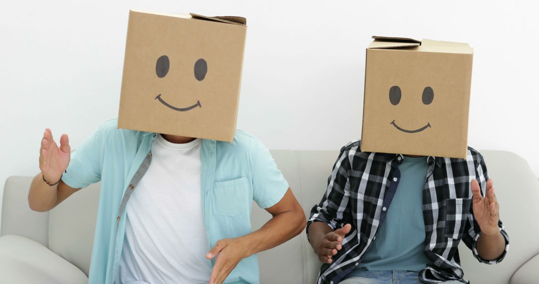 Amusing Friends Wearing Cardboard Boxes with Smiley Faces and Posing - Free Images, Stock Photos and Pictures on Pikwizard.com