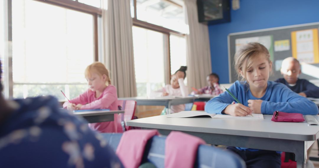 Focused Schoolchildren Writing in Classroom with Bulletin Board