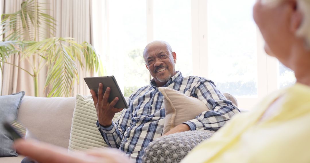 Elderly Man Using Digital Tablet While Relaxing at Home - Free Images, Stock Photos and Pictures on Pikwizard.com