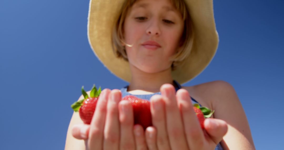 Teenage Caucasian girl holds fresh strawberries outdoors - Free Images, Stock Photos and Pictures on Pikwizard.com