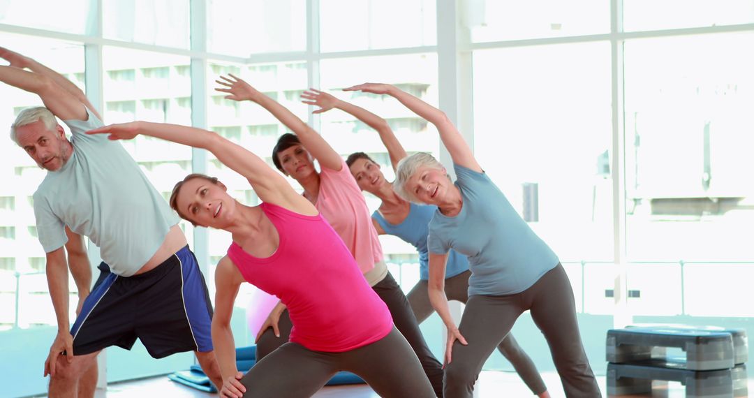 Diverse Group of Adults Doing Yoga Stretches in Bright Yoga Studio - Free Images, Stock Photos and Pictures on Pikwizard.com