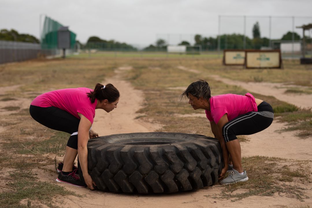 Two Women Lifting Tire in Outdoor Boot Camp Training Session - Free Images, Stock Photos and Pictures on Pikwizard.com