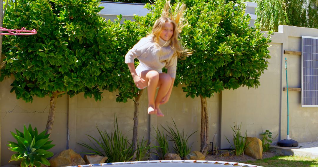 Girl Jumping on Trampoline in Lush Backyard - Free Images, Stock Photos and Pictures on Pikwizard.com