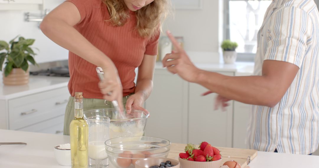 Couple Collaborating to Whisk Batter in Modern Kitchen