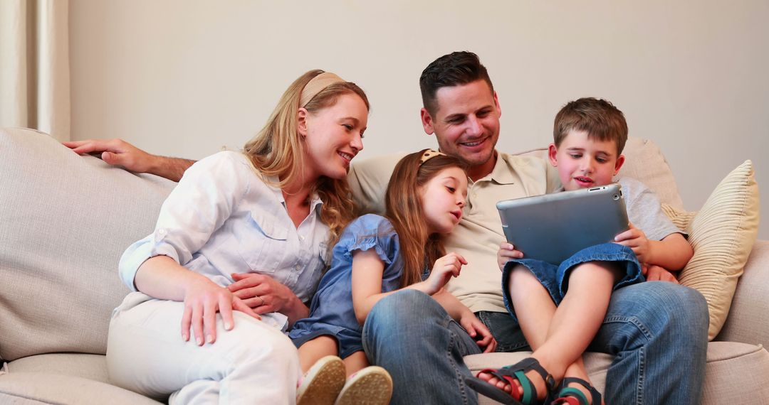 Happy Family Relaxing on Sofa Watching Tablet Together - Free Images, Stock Photos and Pictures on Pikwizard.com