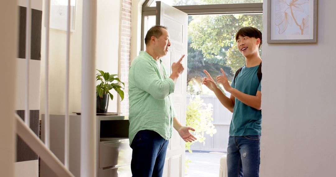 Father and Son Smiling and Pointing at Home Entryway