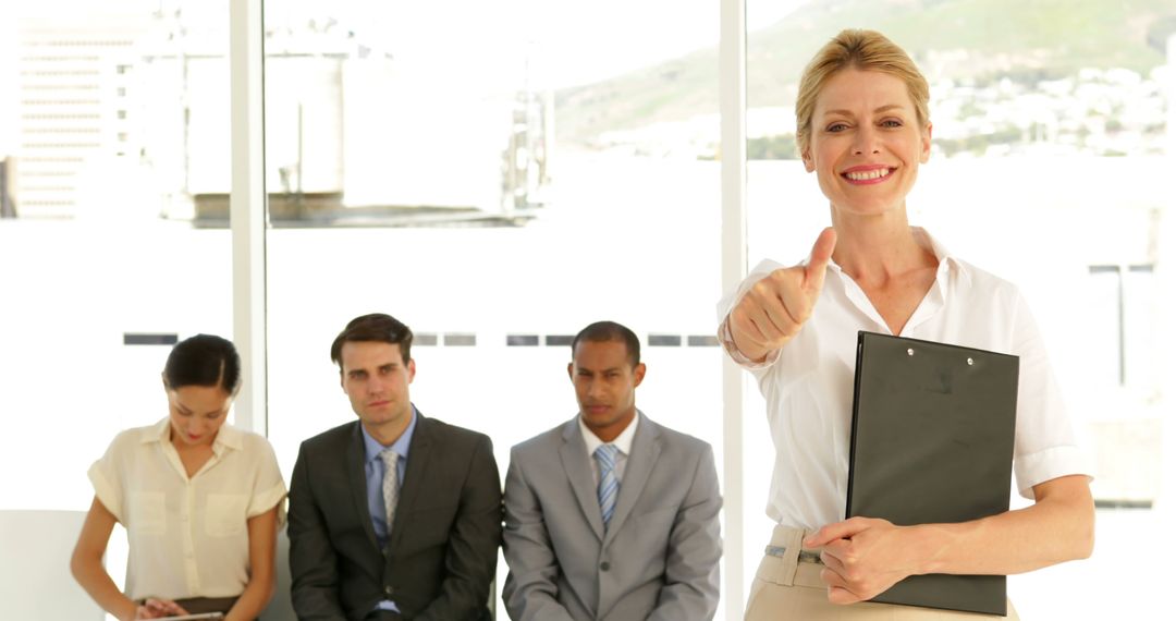 Smiling Businesswoman Holding Clipboard Giving Thumbs Up in Office - Free Images, Stock Photos and Pictures on Pikwizard.com