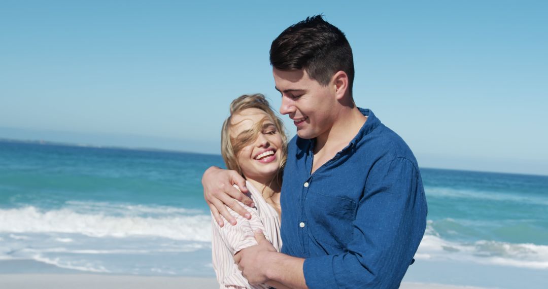 Happy couple embracing on sandy beach with ocean backdrop - Free Images, Stock Photos and Pictures on Pikwizard.com