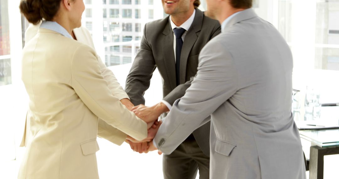 Business Professionals Celebrating Success with Group Handshake in Office - Free Images, Stock Photos and Pictures on Pikwizard.com