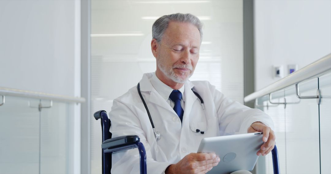 Senior Doctor Using Digital Tablet in Wheelchair at Hospital - Free Images, Stock Photos and Pictures on Pikwizard.com