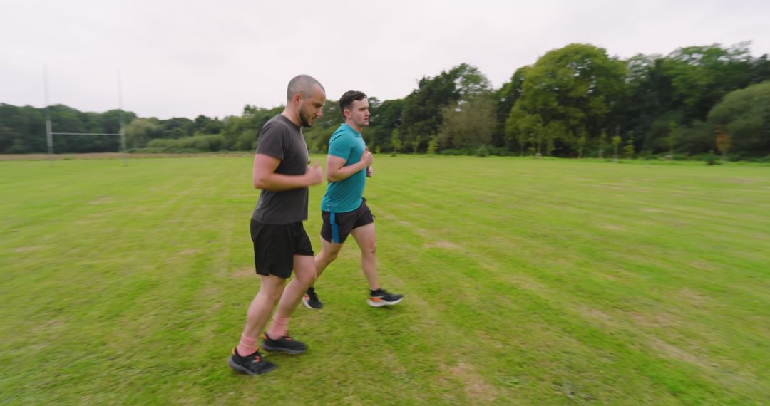Two Men Jogging on Grassy Field in Outdoor Exercise