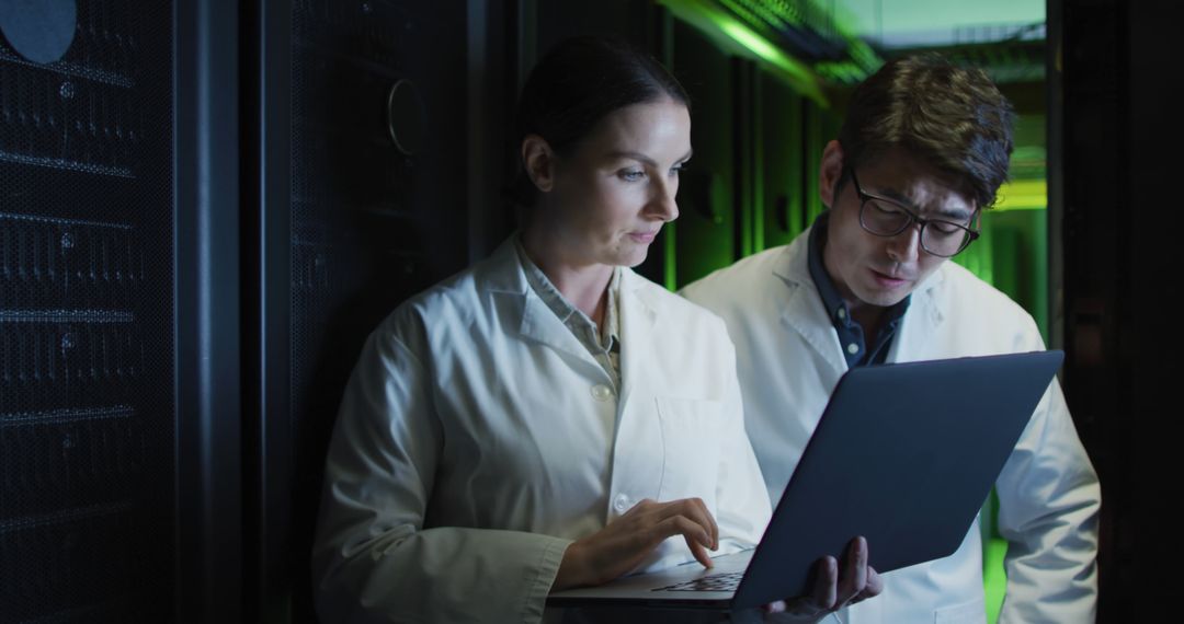 Two Scientists Analyzing Data on Laptop in Server Room - Free Images, Stock Photos and Pictures on Pikwizard.com