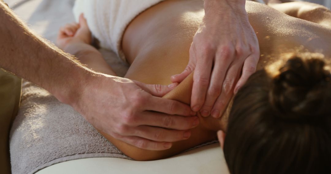 A massage therapist is working on a young Caucasian woman's back, with copy space - Free Images, Stock Photos and Pictures on Pikwizard.com