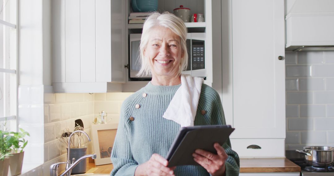 Smiling Senior Woman Using Digital Tablet in Modern Kitchen - Free Images, Stock Photos and Pictures on Pikwizard.com