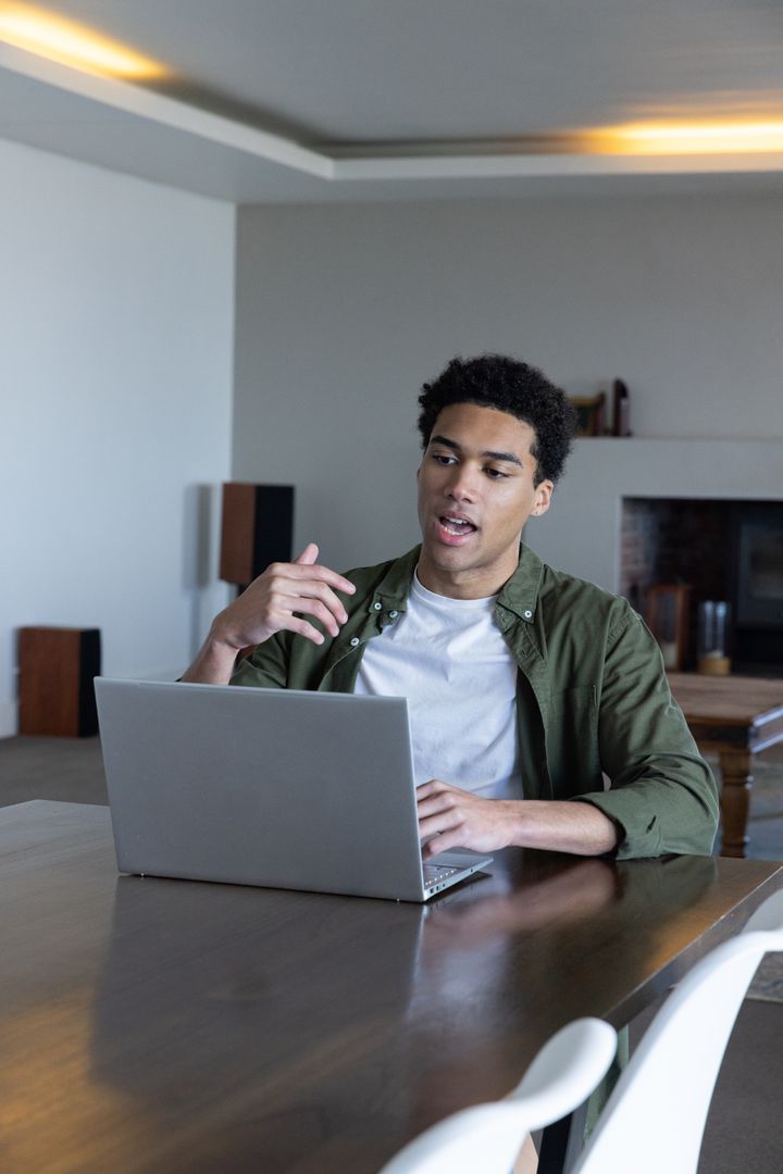 Man Engaging in Virtual Meeting on Laptop at Home Office