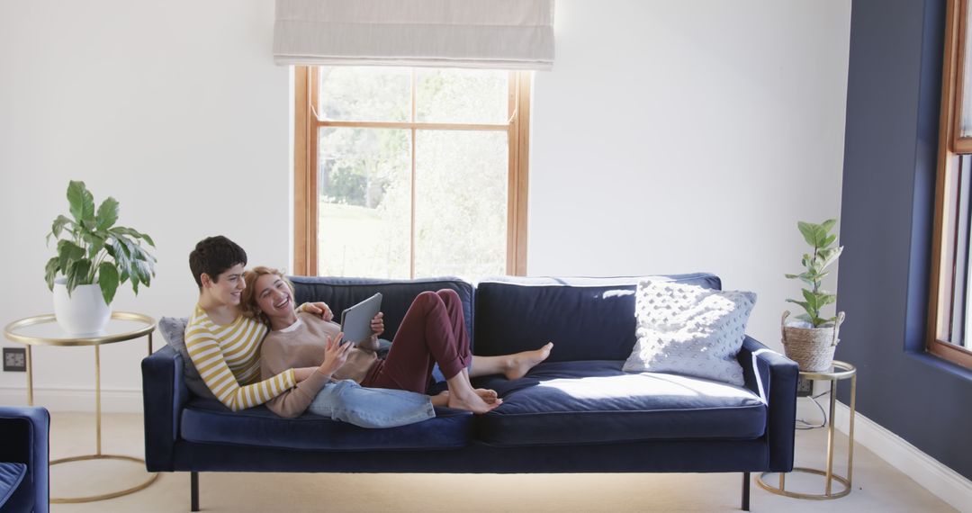 Happy Couple Relaxing on Blue Couch Using Tablet - Free Images, Stock Photos and Pictures on Pikwizard.com