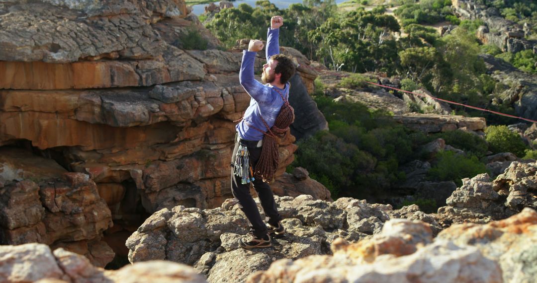 Triumphant Rock Climber Celebrating Success on Clifftop at Sunrise - Free Images, Stock Photos and Pictures on Pikwizard.com