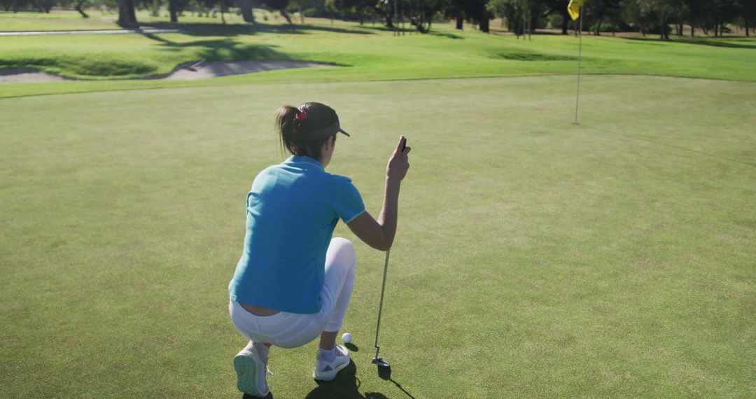 Female Golfer Lining Up Putt on Golf Course - Free Images, Stock Photos and Pictures on Pikwizard.com