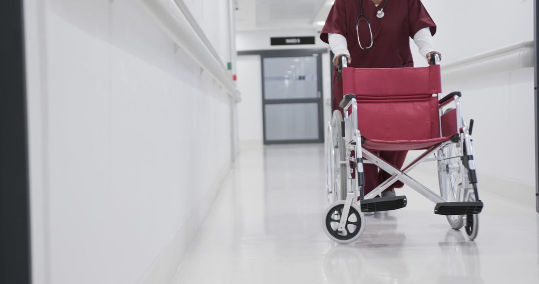 Hospital Staff Pushing Empty Red Wheelchair in Hallway - Free Images, Stock Photos and Pictures on Pikwizard.com