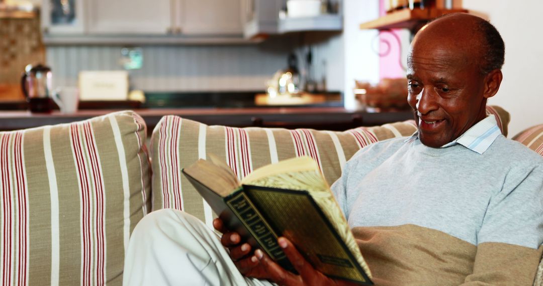 Elderly Man Reading a Book on Comfortable Sofa - Free Images, Stock Photos and Pictures on Pikwizard.com