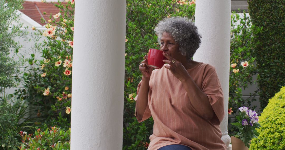 Elderly Woman Enjoying Coffee on Porch Surrounded by Greenery - Free Images, Stock Photos and Pictures on Pikwizard.com