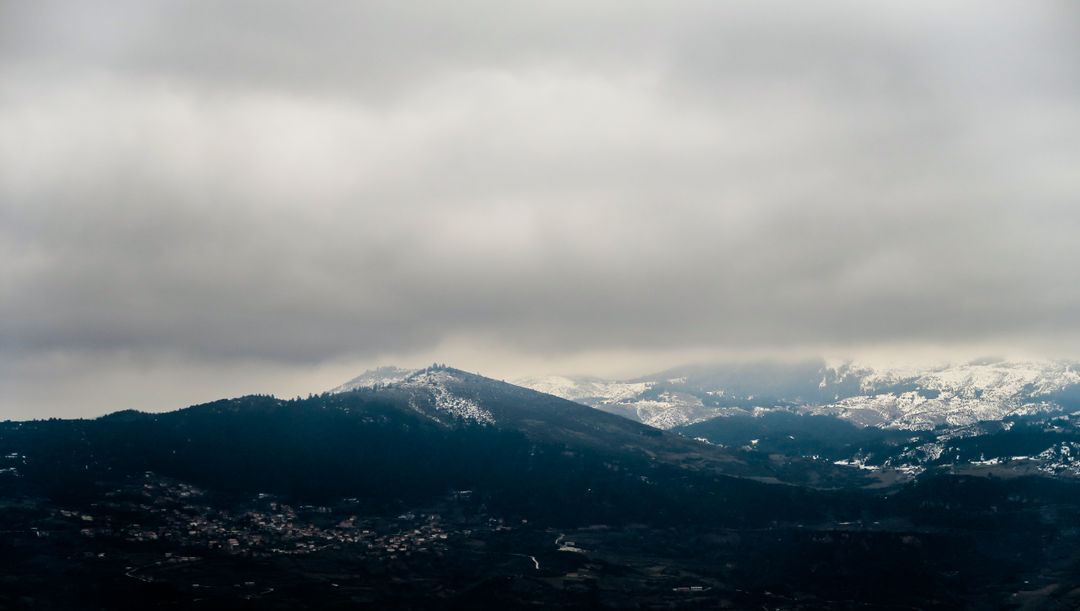 Snow-Covered Mountain Peaks and Dense Cloudy Sky - Free Images, Stock Photos and Pictures on Pikwizard.com