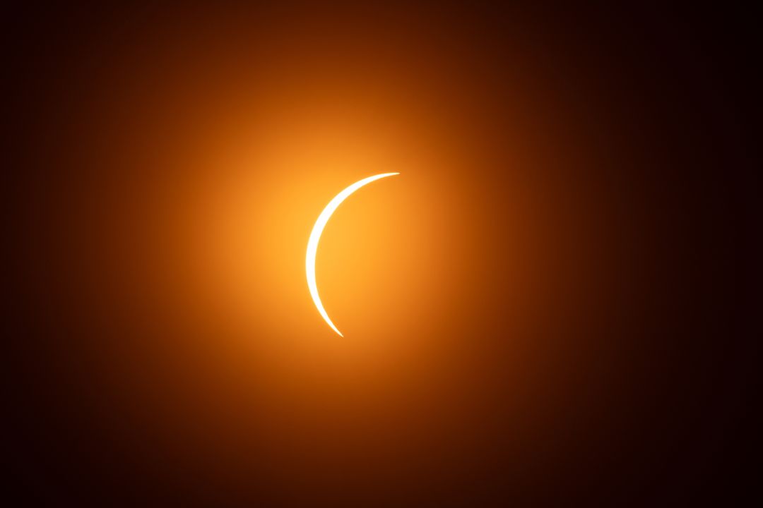 Spectacular solar eclipse with radiant orange universe sky