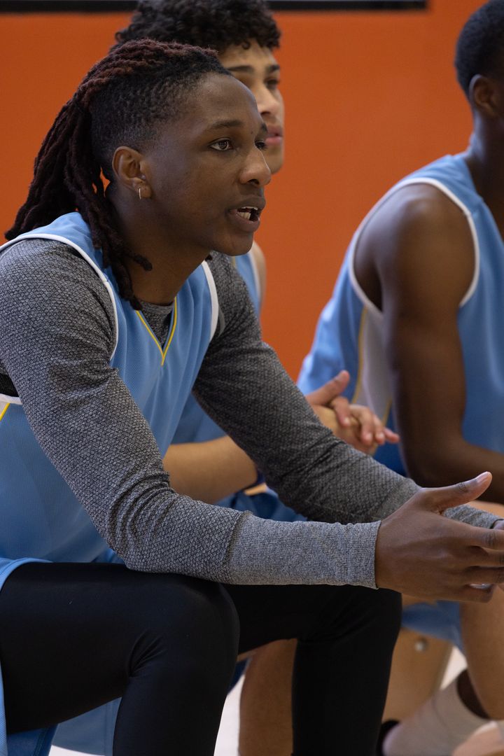 Diverse Men's Basketball Team Discussing Strategy on Sideline