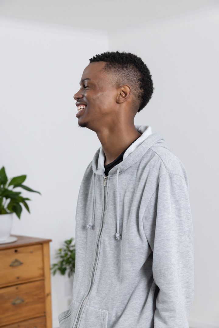 Man in Casual Hoodie Relaxing Indoors with Minimal Decor