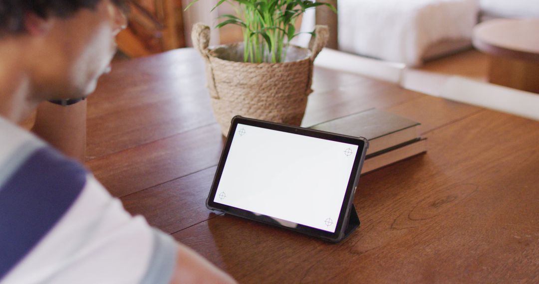 Person Using Tablet on Wooden Desk Near Potted Plant - Free Images, Stock Photos and Pictures on Pikwizard.com