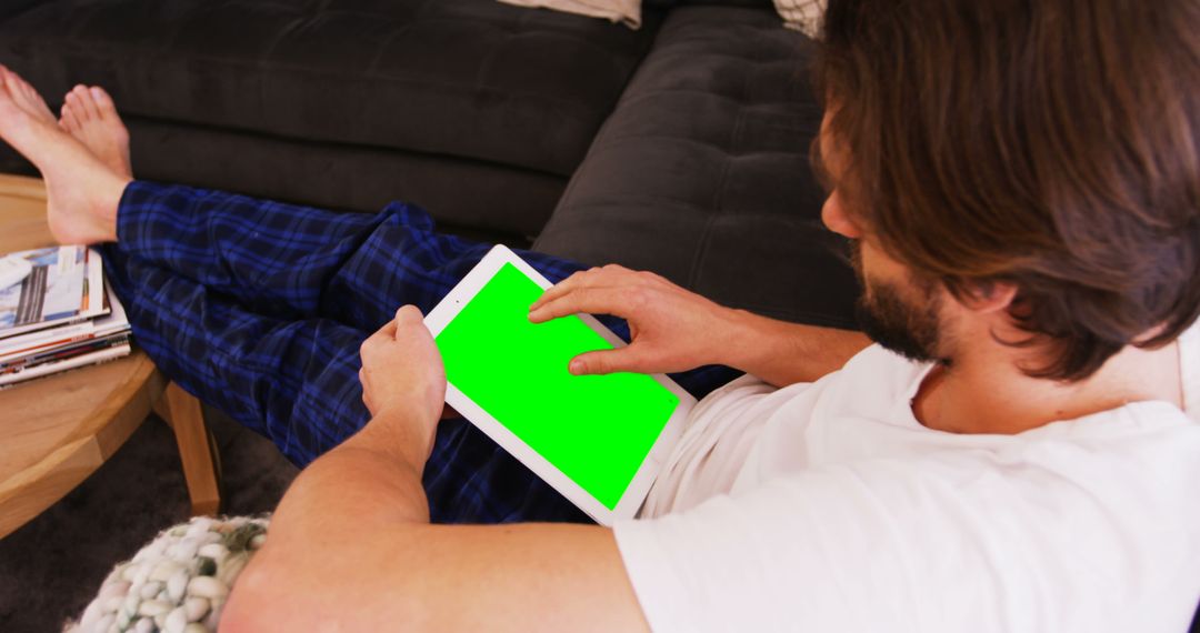 Man Sitting on Sofa Holding Tablet with Green Screen - Free Images, Stock Photos and Pictures on Pikwizard.com