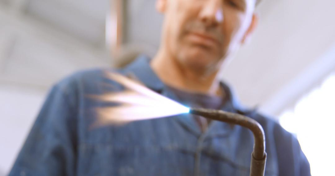 Worker focused on welding with a gas torch in workshop - Free Images, Stock Photos and Pictures on Pikwizard.com