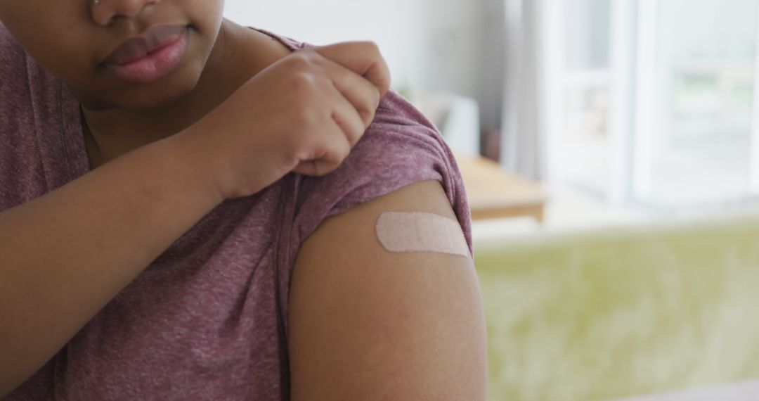 Happy african american woman with bandage on her arm after vaccination - Free Images, Stock Photos and Pictures on Pikwizard.com