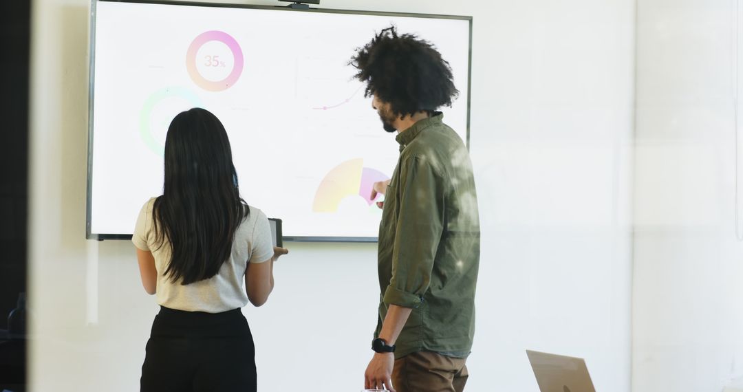 Coworkers Analyzing Data on Digital Screen in Modern Office