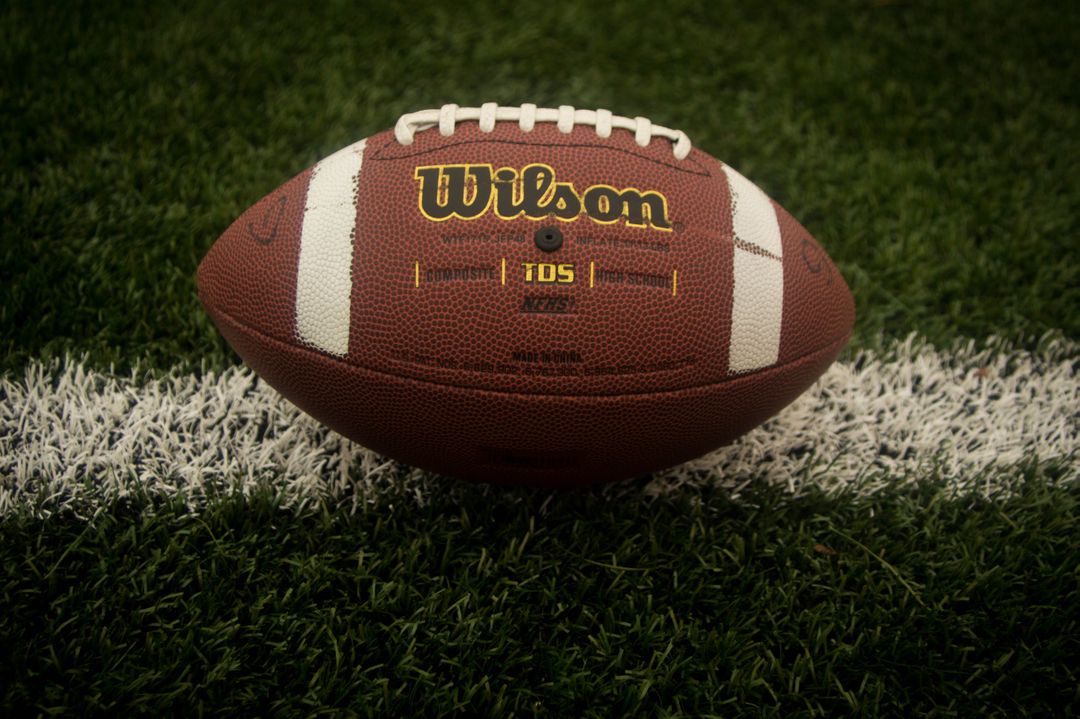 Close-up of Wilson Football on Grass Field - Free Images, Stock Photos and Pictures on Pikwizard.com