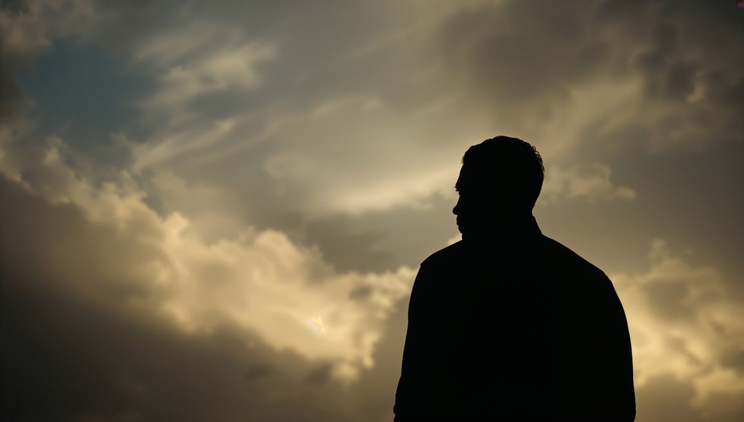 Silhouette of Man Against Dramatic Cloudy Sky