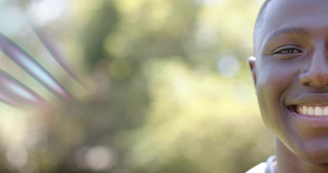 Sunlit smiling young man half-portrait with soft bokeh background and wide copy space