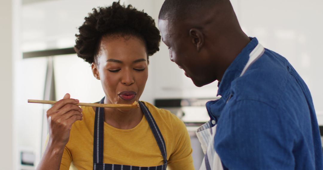 Image of happy african american couple cooking together, trying dish - Free Images, Stock Photos and Pictures on Pikwizard.com