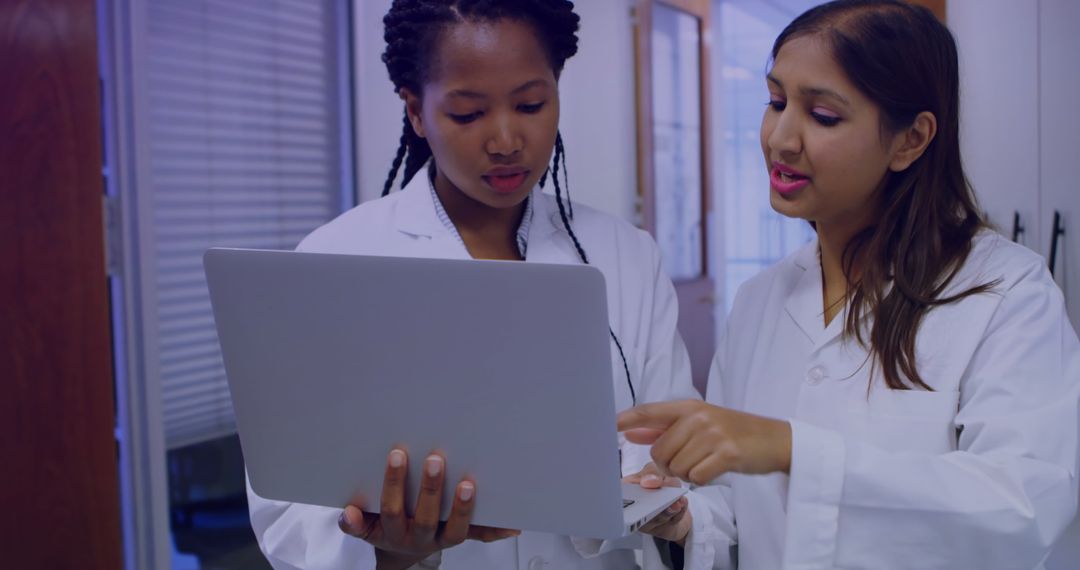 Diverse Female Scientists Analyzing Data on Laptop in Laboratory