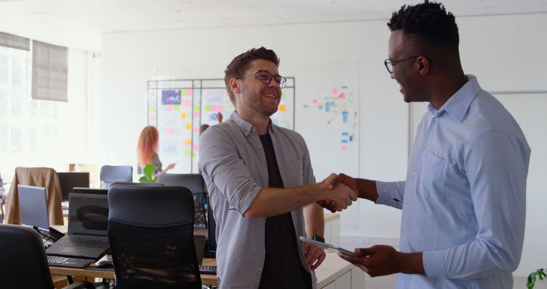 Colleagues Shaking Hands in Modern Office Workspace