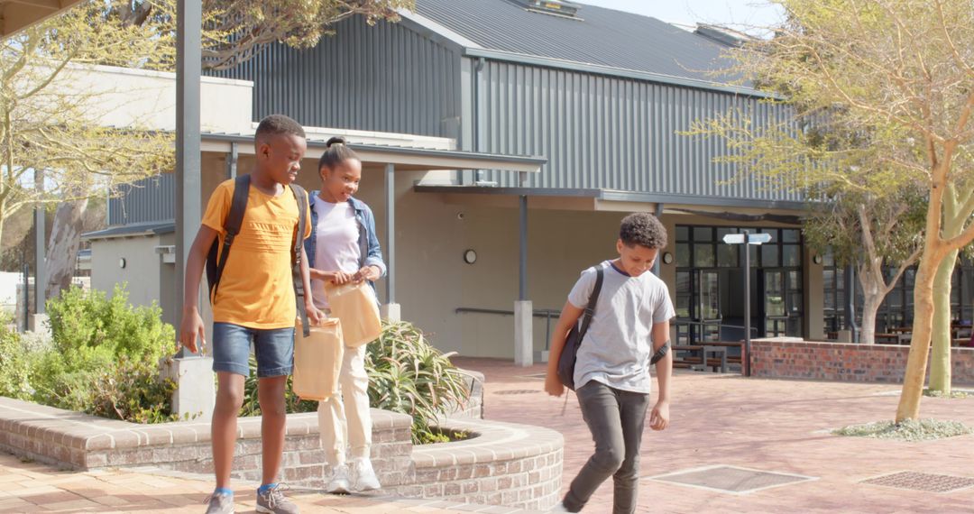 Diverse Students Walking in School Courtyard with Backpacks