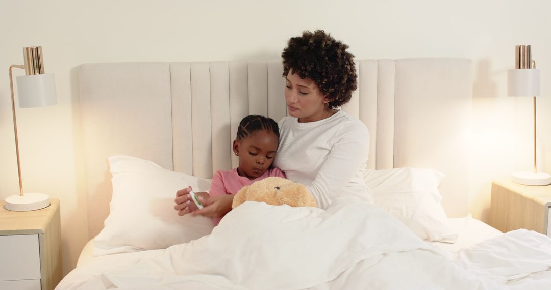 Mother Comforting Child in Bed Holding Thermometer Reflecting Warmth and Care