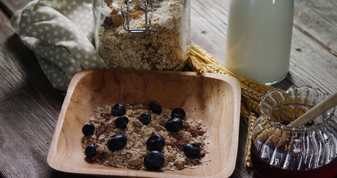 A rustic breakfast scene features oatmeal with blueberries, honey, and milk. - Free Images, Stock Photos and Pictures on Pikwizard.com