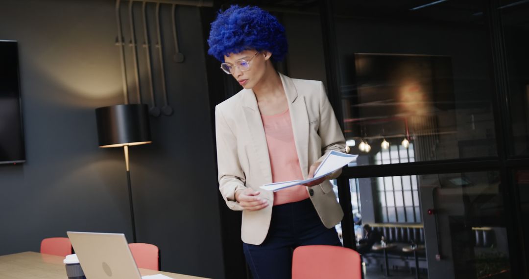 Businesswoman with Blue Wig Reviewing Documents in Modern Office - Free Images, Stock Photos and Pictures on Pikwizard.com