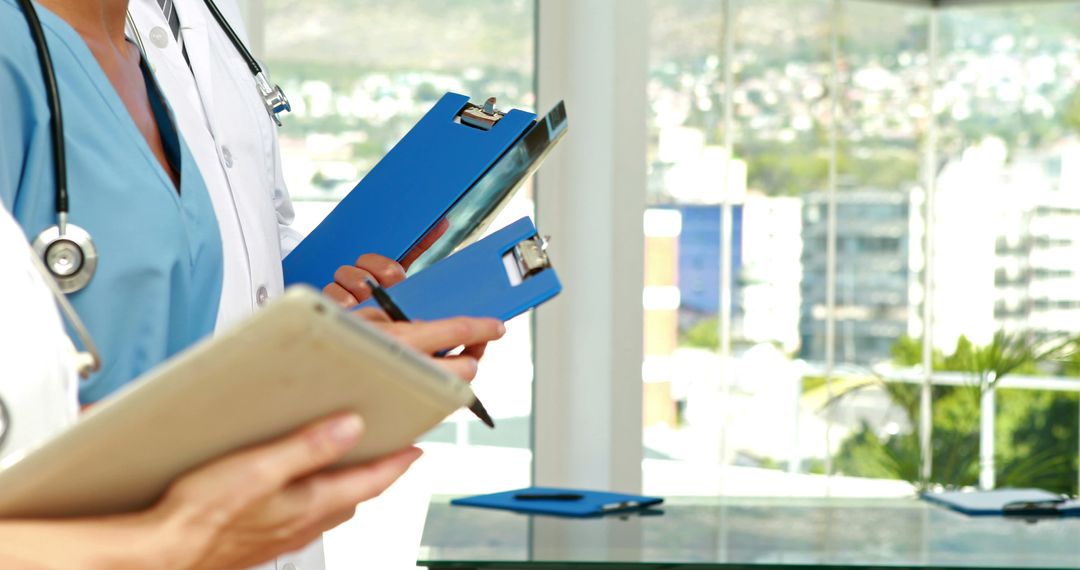 Healthcare Professionals with Digital Tablets and Clipboards in Modern Office - Free Images, Stock Photos and Pictures on Pikwizard.com