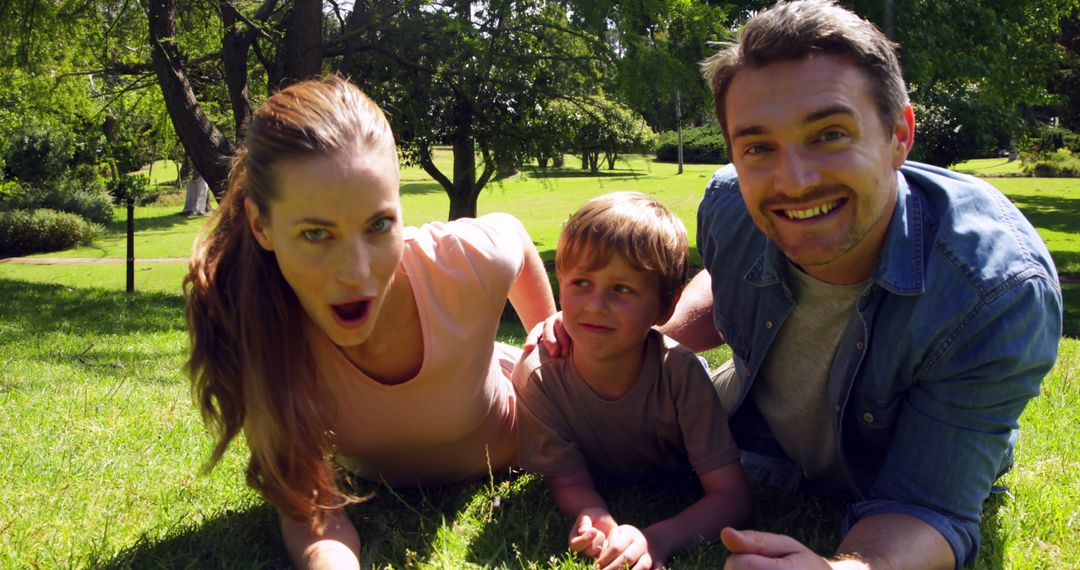 Happy Family Enjoying Time Outdoors Lying on Grass in Park - Free Images, Stock Photos and Pictures on Pikwizard.com