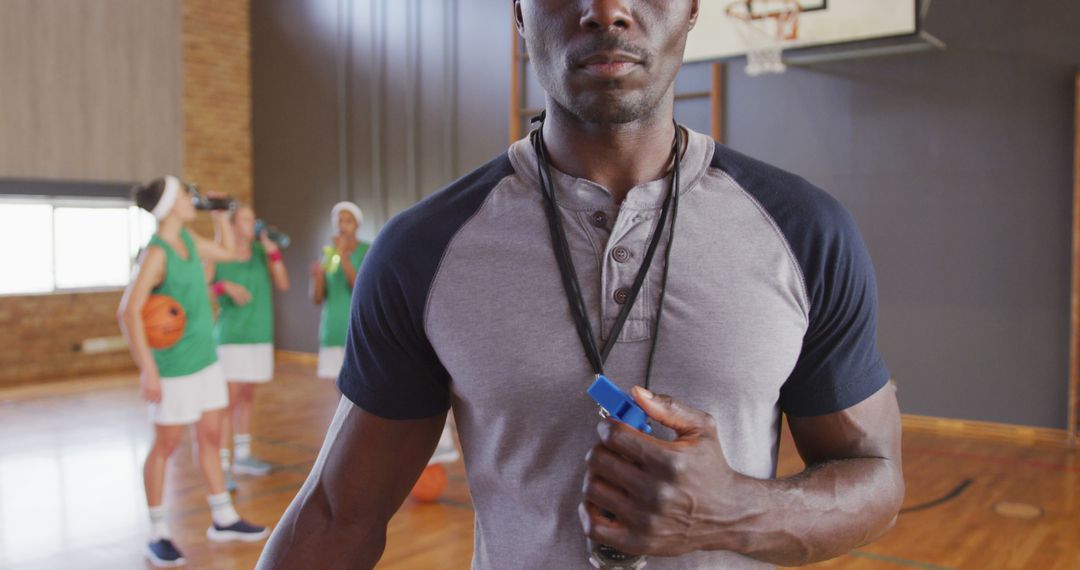 Portrait of african american male coach with diverse female basketball team in background - Free Images, Stock Photos and Pictures on Pikwizard.com