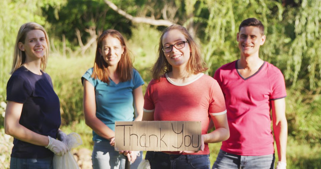 Group of Young Volunteers Holding Thank You Sign Outdoors - Free Images, Stock Photos and Pictures on Pikwizard.com