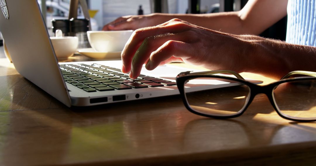 Close-up of Hands Typing on Laptop in Sunlit Café - Free Images, Stock Photos and Pictures on Pikwizard.com