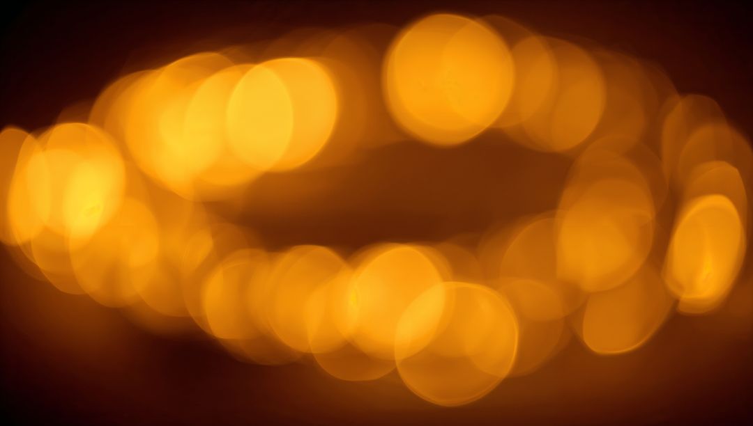 Warm golden bokeh lights forming soft horizontal arc, glowing orbs background for design